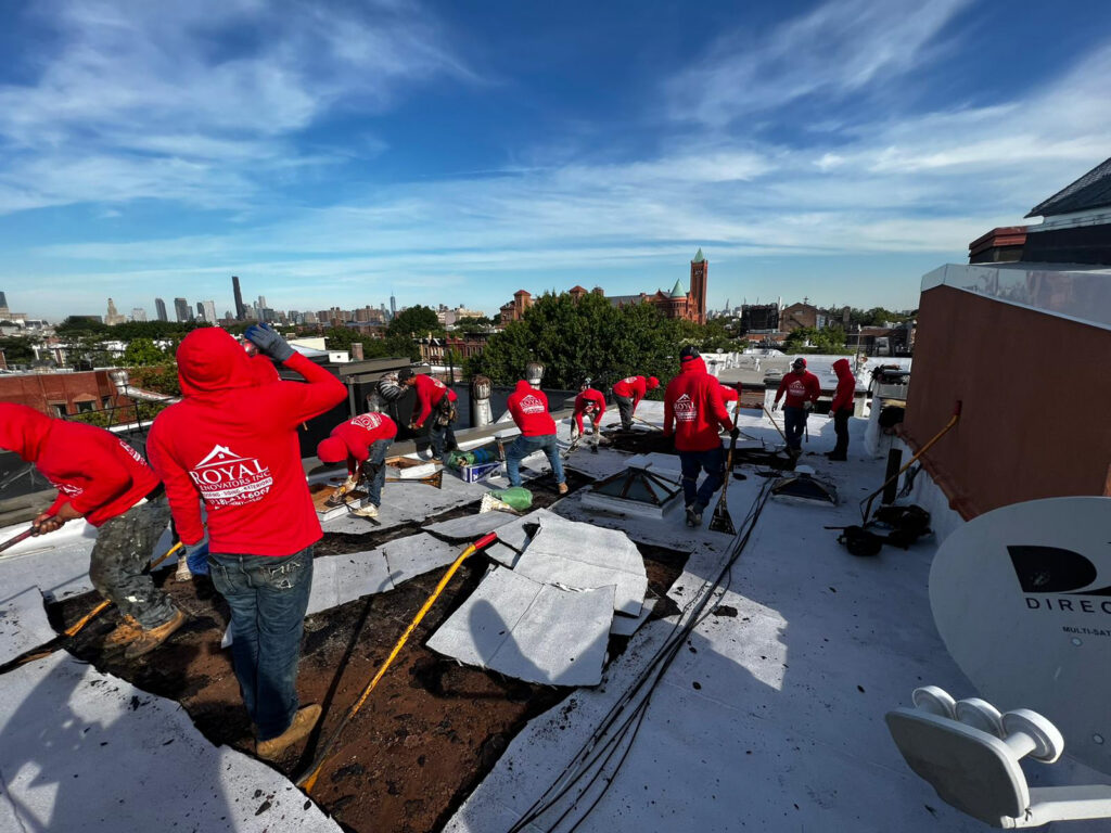 Flat roof problems NYC showing ponding water and roof damage on urban building